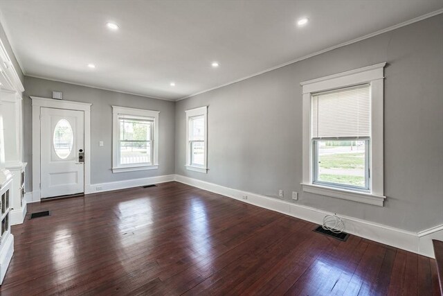 foyer entrance with dark wood-type flooring, ornamental molding, baseboards, and recessed lighting