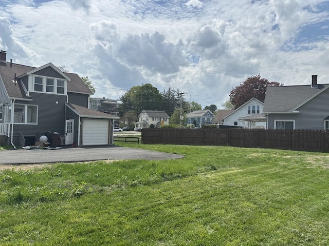 view of yard featuring asphalt driveway and a residential view