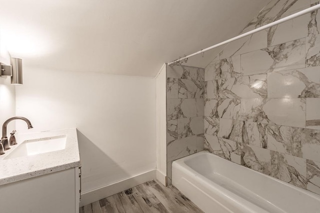 bathroom with vanity, baseboards, shower / bath combination, and wood finished floors