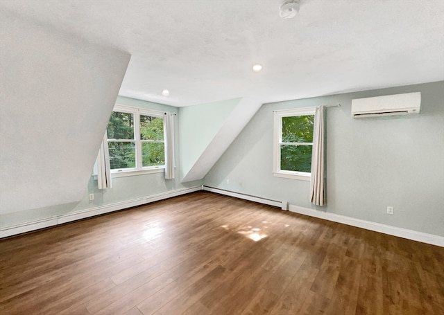 bonus room featuring a healthy amount of sunlight, an AC wall unit, and wood-type flooring