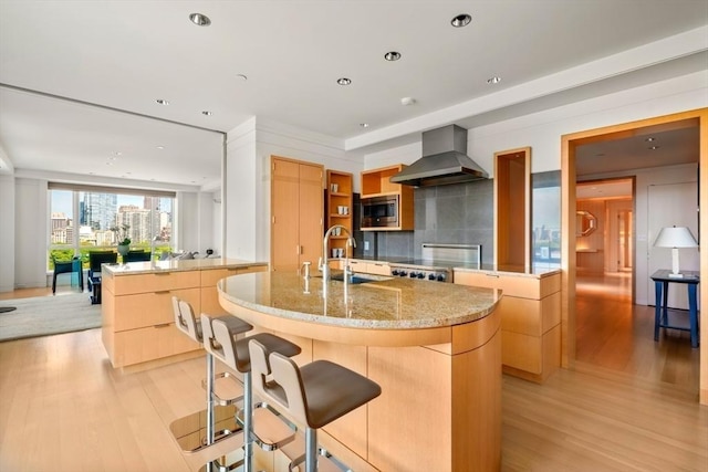 2 Commonwealth Ave Unit 15Bc, Boston, MA 02116 - kitchen featuring island range hood, stainless steel microwave, a center island with sink, a sink, and modern cabinets