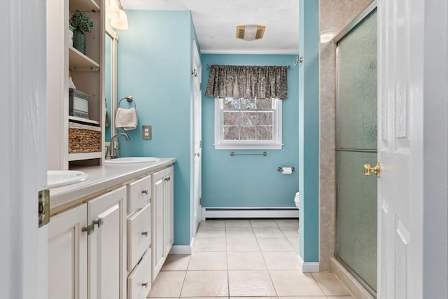 bathroom featuring double vanity, tile patterned flooring, a shower stall, a baseboard heating unit, and a sink