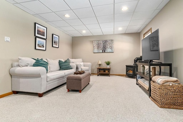 living room featuring recessed lighting, a wood stove, carpet flooring, and baseboards