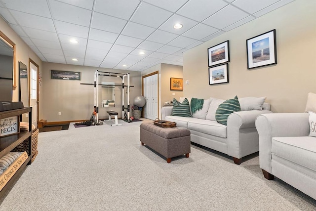 carpeted living area with baseboards, a drop ceiling, and recessed lighting