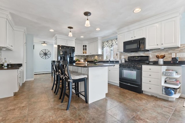 kitchen with dark countertops, black appliances, a baseboard heating unit, and white cabinets