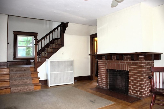 142 College St, Worcester, MA 01610 - unfurnished living room featuring wood finished floors, stairs, a fireplace, and ceiling fan