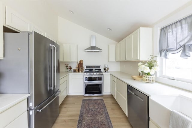 99 Dartmouth St, Westfield, MA 01085 - kitchen featuring appliances with stainless steel finishes, wall chimney range hood, white cabinets, lofted ceiling, and light wood-style flooring