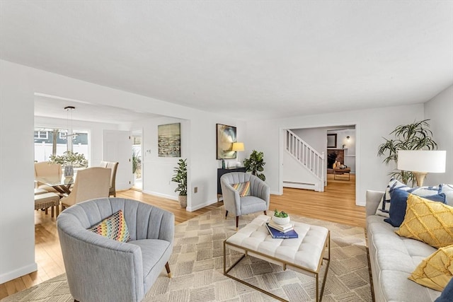 living area with light wood finished floors, stairs, baseboards, and baseboard heating