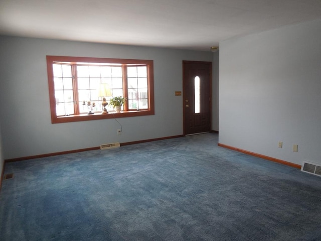 spare room with dark colored carpet