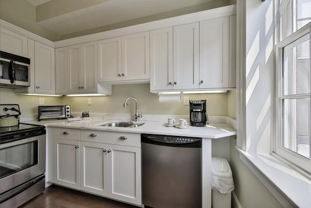 26 Winter St, Salem, MA 01970 - kitchen featuring appliances with stainless steel finishes, a sink, plenty of natural light, and white cabinets