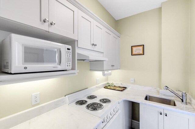 26 Winter St, Salem, MA 01970 - kitchen with white appliances, a sink, under cabinet range hood, white cabinetry, and light stone countertops