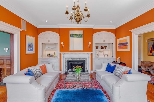 26 Winter St, Salem, MA 01970 - living area with a chandelier, built in shelves, crown molding, a high end fireplace, and wood finished floors