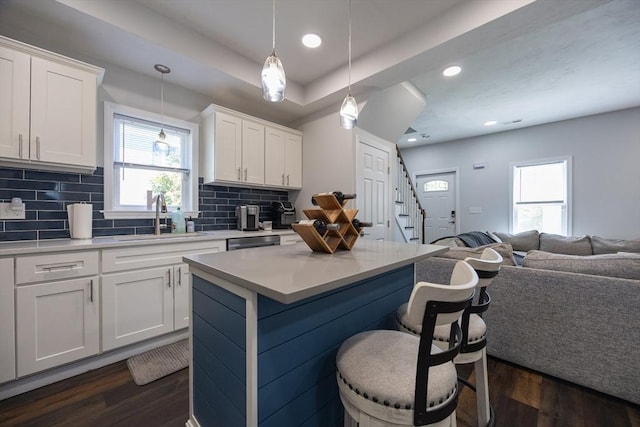 12 Fairmount Ave, Brockton, MA 02301 - kitchen featuring dark wood-style floors, open floor plan, decorative backsplash, a breakfast bar, and light countertops