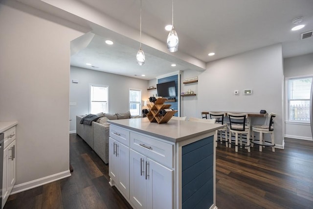 12 Fairmount Ave, Brockton, MA 02301 - kitchen featuring dark wood finished floors, white cabinetry, pendant lighting, light countertops, and a kitchen island