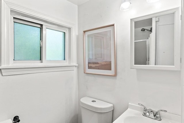 bathroom featuring a sink, toilet, and a shower