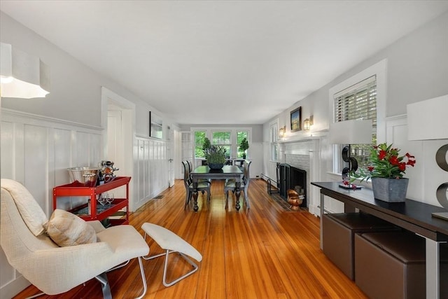 117 Parker Rd, Barnstable, MA 02655 - living area with wood finished floors, a decorative wall, a fireplace, and wainscoting