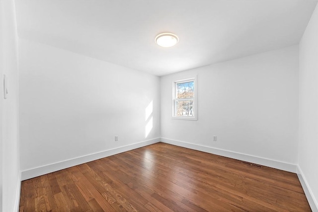 spare room featuring wood-type flooring