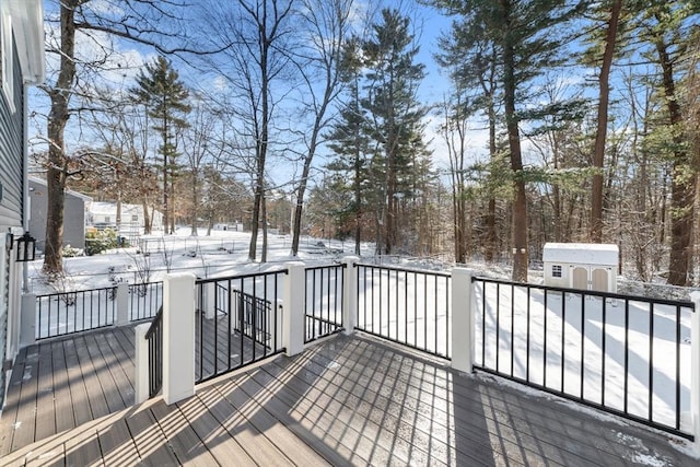 snow covered deck with a shed