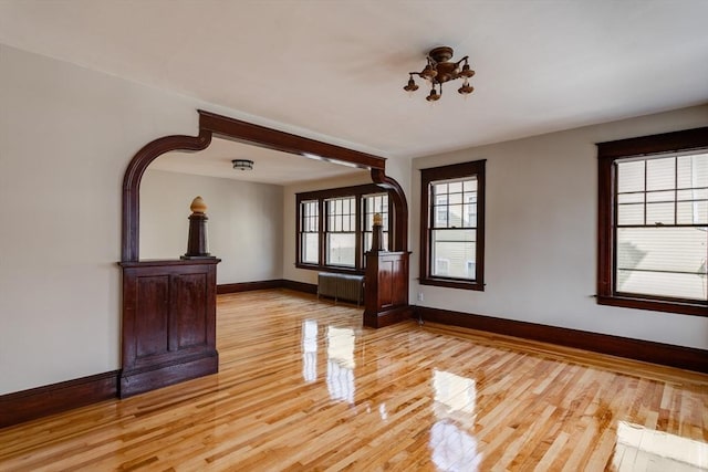 174 Vernon St, Worcester, MA 01610 - unfurnished living room with radiator, baseboards, light wood-type flooring, and a chandelier
