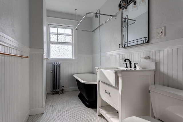 174 Vernon St, Worcester, MA 01610 - full bath with radiator, wainscoting, a soaking tub, vanity, and toilet