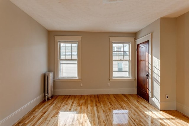 174 Vernon St, Worcester, MA 01610 - unfurnished room featuring radiator, light wood-style floors, baseboards, healthy amount of natural light, and a textured ceiling