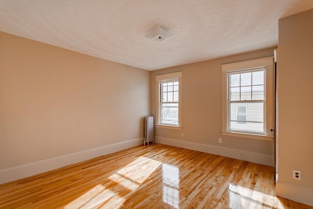 174 Vernon St, Worcester, MA 01610 - unfurnished room featuring radiator, light wood-style flooring, and baseboards