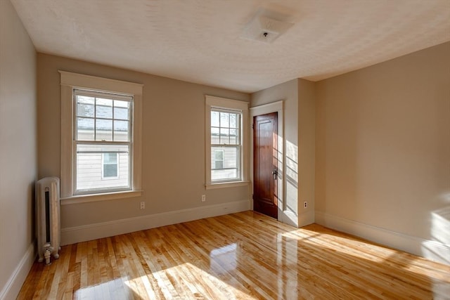 174 Vernon St, Worcester, MA 01610 - unfurnished room featuring radiator, light wood-style floors, baseboards, and plenty of natural light