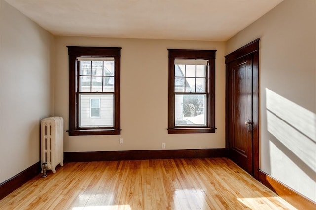 174 Vernon St, Worcester, MA 01610 - empty room with radiator heating unit, light wood-style floors, and baseboards