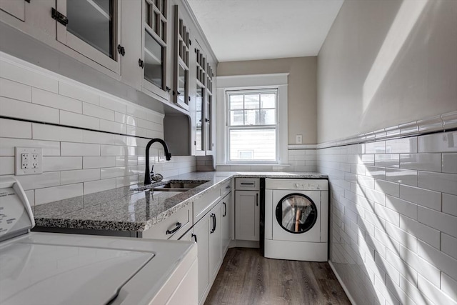 174 Vernon St, Worcester, MA 01610 - laundry area with washer / clothes dryer, dark wood finished floors, tile walls, cabinet space, and a wainscoted wall