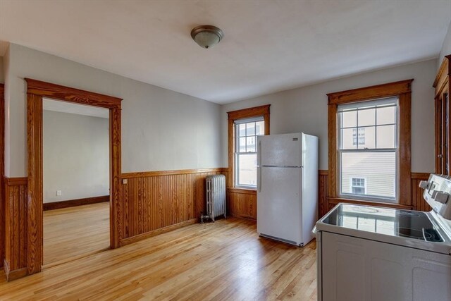174 Vernon St, Worcester, MA 01610 - kitchen featuring freestanding refrigerator, a wainscoted wall, radiator, electric range, and light wood-style floors