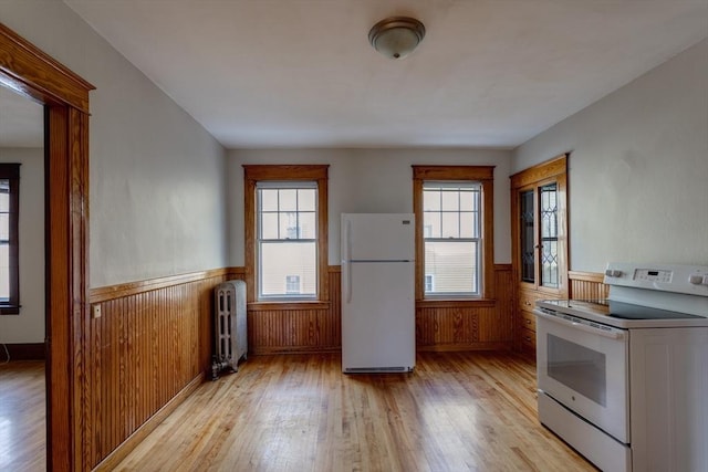 174 Vernon St, Worcester, MA 01610 - kitchen with white appliances, radiator, wainscoting, light wood-style flooring, and plenty of natural light