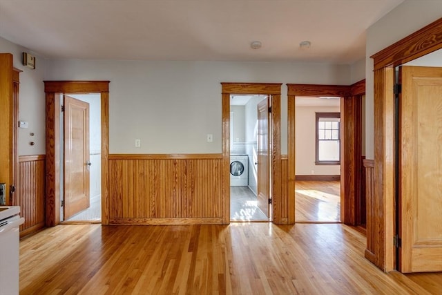 174 Vernon St, Worcester, MA 01610 - empty room with a wainscoted wall, light wood finished floors, and stacked washing machine and dryer