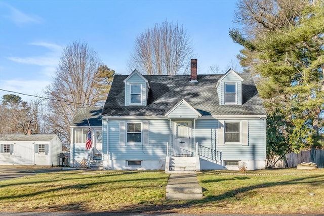 new england style home featuring a shed and a front yard