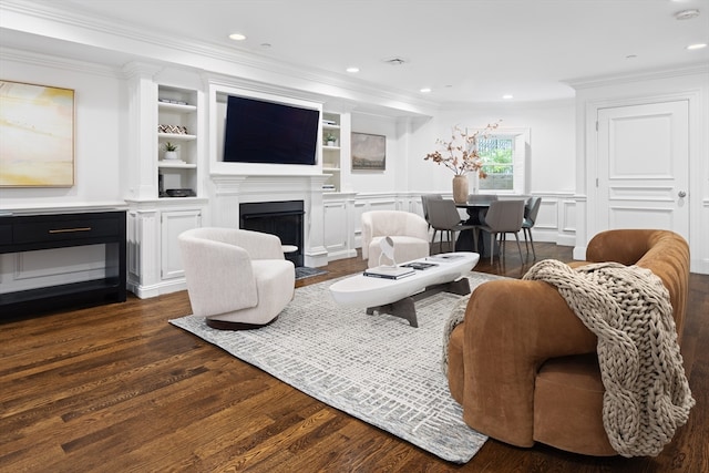 living room featuring built in features, dark hardwood / wood-style flooring, and ornamental molding