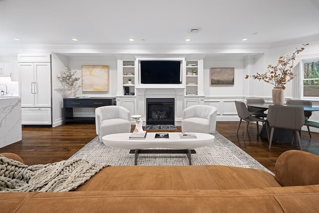 living room featuring crown molding, dark wood-type flooring, and built in features