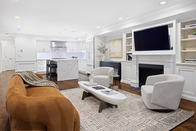 living room with ornamental molding, hardwood / wood-style floors, and built in shelves