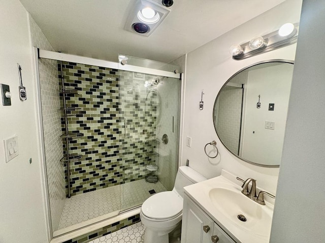 bathroom featuring vanity, a shower stall, and toilet