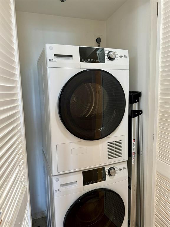 washroom with laundry area and stacked washer / drying machine