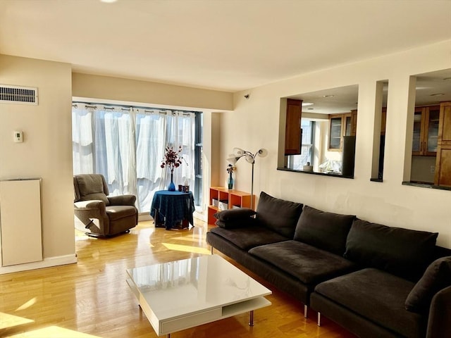 living area featuring light wood-style flooring and visible vents