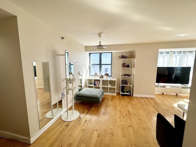 living area featuring light wood-style flooring and baseboards