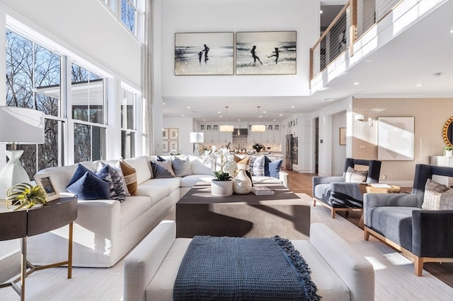 living room featuring a towering ceiling and light hardwood / wood-style floors