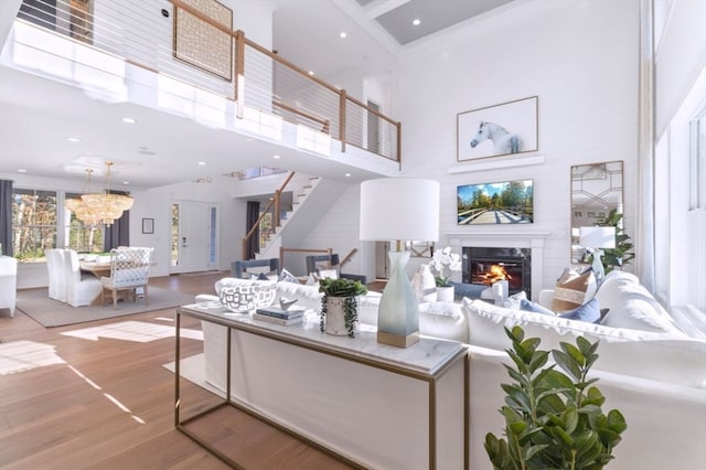 living room featuring an inviting chandelier, a high ceiling, and hardwood / wood-style flooring