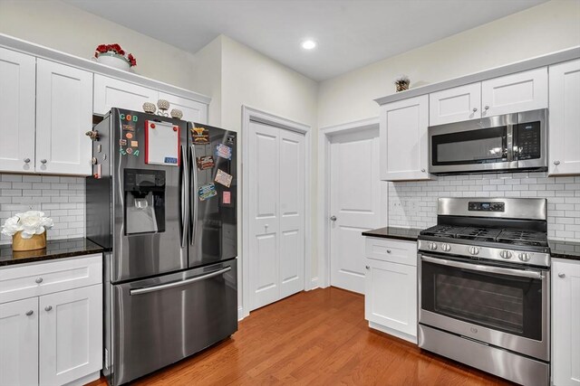 131 Rogerson Xing Unit 131, Uxbridge, MA 01569 - kitchen featuring stainless steel appliances, white cabinets, light wood-style flooring, decorative backsplash, and recessed lighting