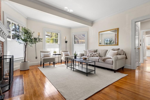 living area with baseboards, ornamental molding, and light wood finished floors