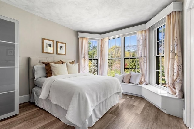 bedroom with visible vents and wood finished floors