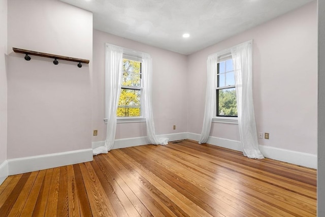 spare room with light wood-style floors and baseboards