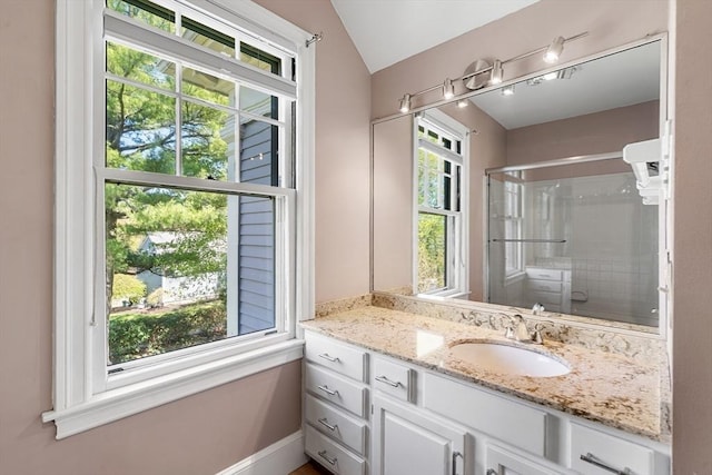 bathroom with an enclosed shower, baseboards, vaulted ceiling, and vanity