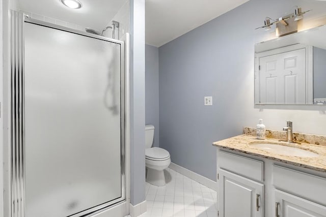bathroom featuring vanity, tile patterned flooring, toilet, baseboards, and a stall shower