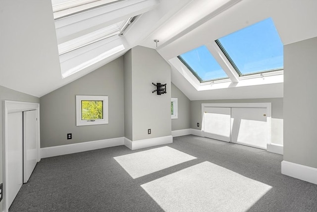 bonus room with vaulted ceiling with skylight, plenty of natural light, and carpet flooring