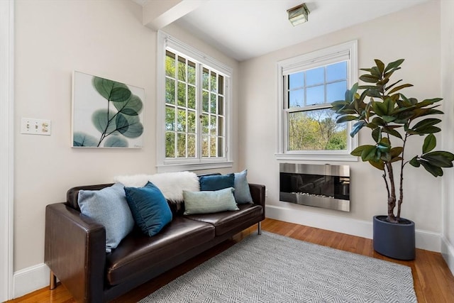 interior space with heating unit, baseboards, and wood finished floors